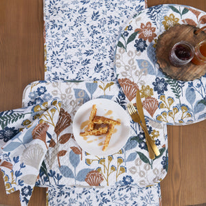 table linens with a mixture of floral, geometric, and retro botanical prints, in a refreshing color palette on a wood table