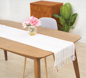 runner with delicate and colorful stripes on a white background and fringed edges on a table