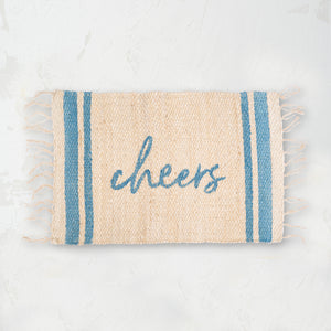 holiday jute rug with light blue text that reads cheers