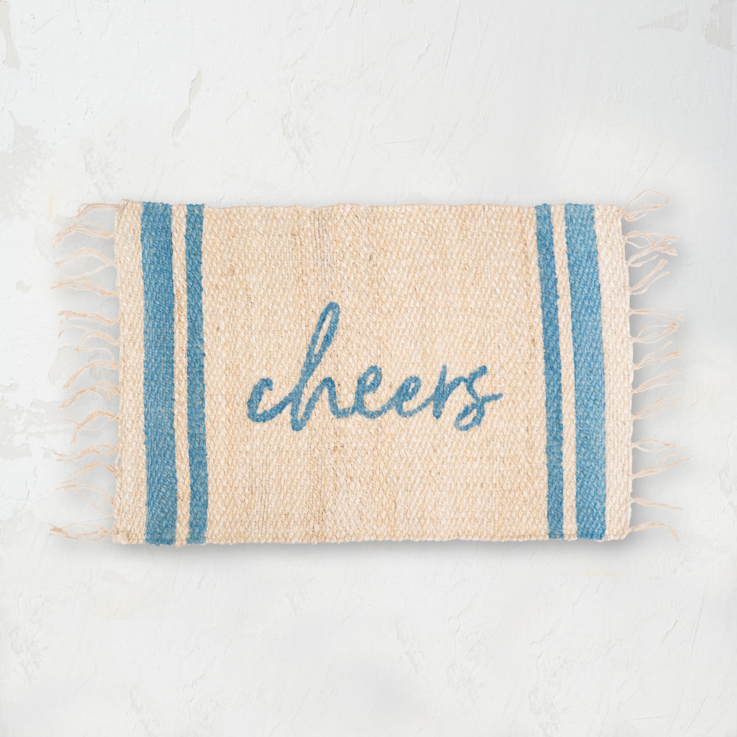 holiday jute rug with light blue text that reads cheers