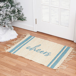 holiday jute rug with light blue text that reads cheers in front of a door