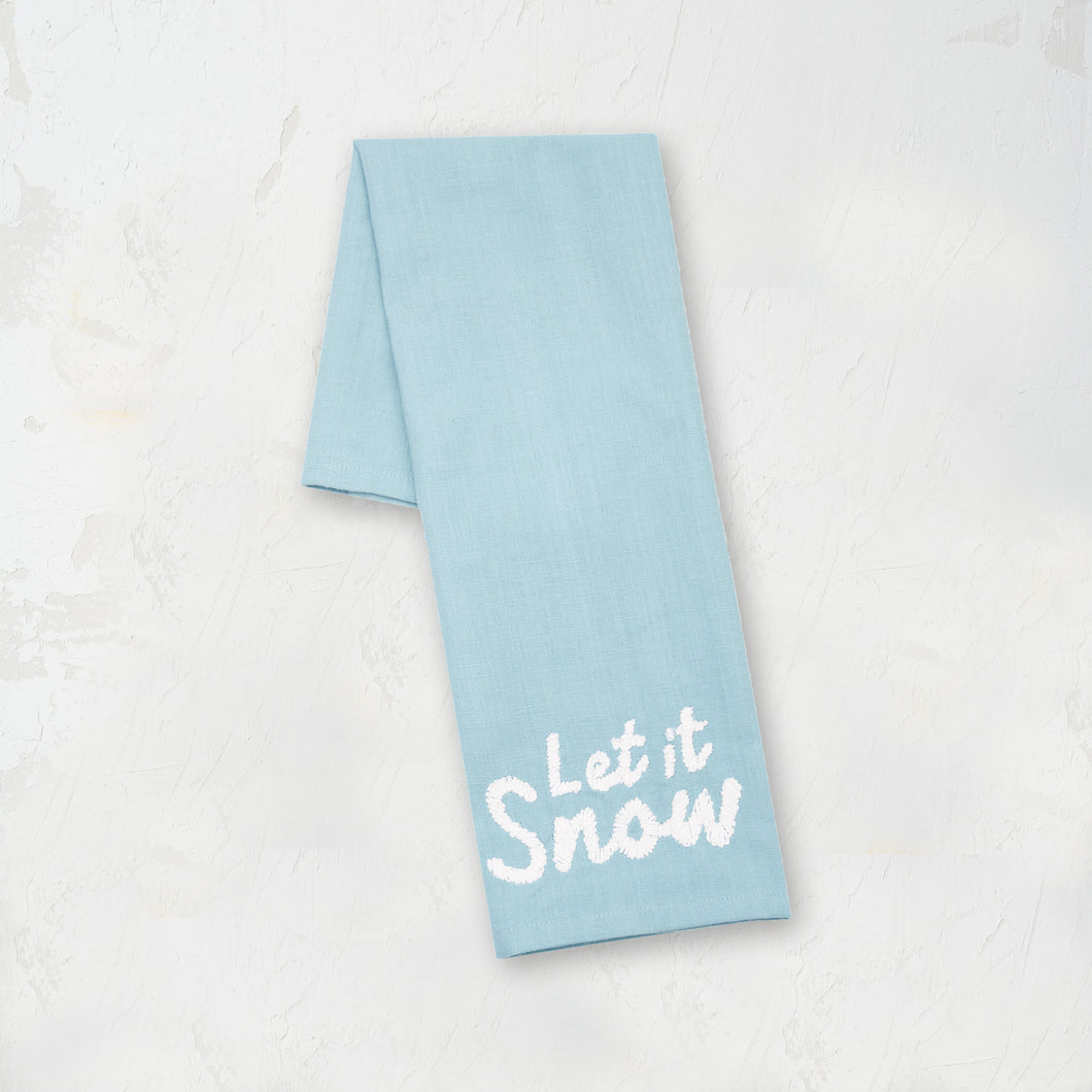 light blue kitchen towel with the words let it snow in white