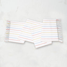 runner with delicate and colorful stripes on a white background and fringed edges